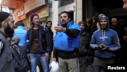 United Nations members arrive to the besieged neighborhoods of Homs in Syria, to supply humanitarian aid, Feb. 8, 2014. 