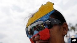  Un partidario del líder opositor Juan Guaidó usa un mapa de Venezuela como máscara durante un mitin antigubernamental al que se esperaba que asistiera Guaidó, pero que no llegó, en Barquisimeto, Venezuela. Abril 28, 2019.