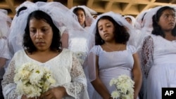 FILE - Women dressed as brides protest in commemoration of the international day for the elimination of violence against women, outside the Supreme Court in Guatemala City, Nov. 26, 2007.