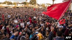 Les Marocains crient des slogans et agitent un drapeau après avoir assisté aux funérailles de deux frères morts en creusant dans une mine de charbon abandonnée dans la ville de Jerada au nord-est, à 60 kilomètres au sud-ouest d'Oujda dans la région orient