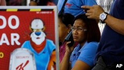Workers wait for information about their jobs outside the Kellogg's factory in Maracay, Venezuela, May 15, 2018. Workers arriving Tuesday for the early shift were surprised to find a notice taped to an iron gate informing them that the company had been forced to shutter its operations.
