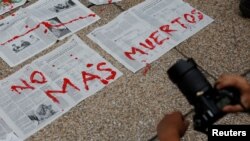 Journalists and activist paint on news papers with fake blood during a protest against the murder of the Mexican journalist Miroslava Breach, outside the Attorney General's Office (PGR) in Mexico City, Mexico, March 25, 2017.