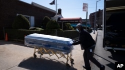 FILE - In this Friday, March 27, 2020 file photo, William Samuels delivers caskets to the Gerard Neufeld Funeral Home during the coronavirus pandemic in the Queens borough of New York. A report by the Centers for Disease Control and Prevention…