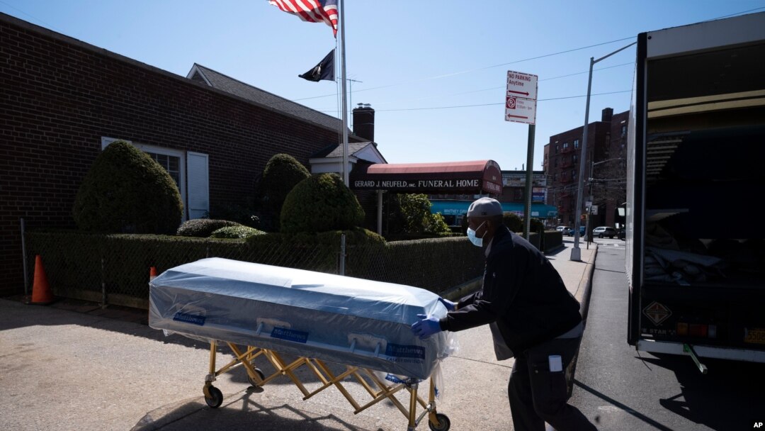 FILE - In this March 27, 2020, photo, William Samuels delivers caskets to the Gerard Neufeld Funeral Home during the coronavirus pandemic in the Queens borough of New York.