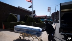 FILE - In this March 27, 2020, photo, William Samuels delivers caskets to the Gerard Neufeld Funeral Home during the coronavirus pandemic in the Queens borough of New York.