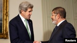 U.S. Secretary of State John Kerry (L) shakes hands with Egypt's President Mohamed Mursi at the Presidential Palace in Cairo March 3, 2013. 