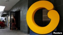 FILE - An employee walks through a door at the headquarters of Venezuelan TV channel Globovision, in Caracas, Venezuela, March 12, 2013.