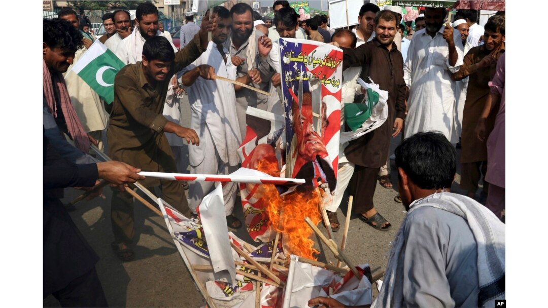 Pakistani protesters burn posters of U. S. President Donald Trump in Peshawar, Pakistan, Aug. 30, 2017. Protesters have objected to Trump's allegation that Islamabad is harboring militants who battle U.S. forces in Afghanistan.