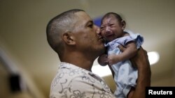 FILE - Geovane Silva holds his son, Gustavo Henrique, who has microcephaly, at the Oswaldo Cruz Hospital in Recife, Brazil, Jan. 26, 2016. 