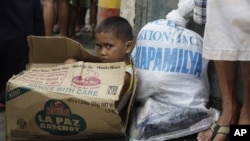  A Filipino boy sits inside an empty carton of noodles as he waits for his parents to receive relief goods, in Quezon City, Philippines, August 13, 2012. 