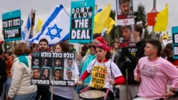 Supporters of Israelis held hostage in the Gaza Strip since October 2023 lift placards and flags during a rally in front of the prime minister's office in Jerusalem on Feb. 11, 2025. 