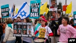 Supporters of Israelis held hostage in the Gaza Strip since October 2023 lift placards and flags during a rally in front of the prime minister's office in Jerusalem on Feb. 11, 2025. 