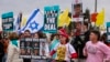 Supporters of Israelis held hostage in the Gaza Strip since October 2023 lift placards and flags during a rally in front of the prime minister's office in Jerusalem on Feb. 11, 2025. 