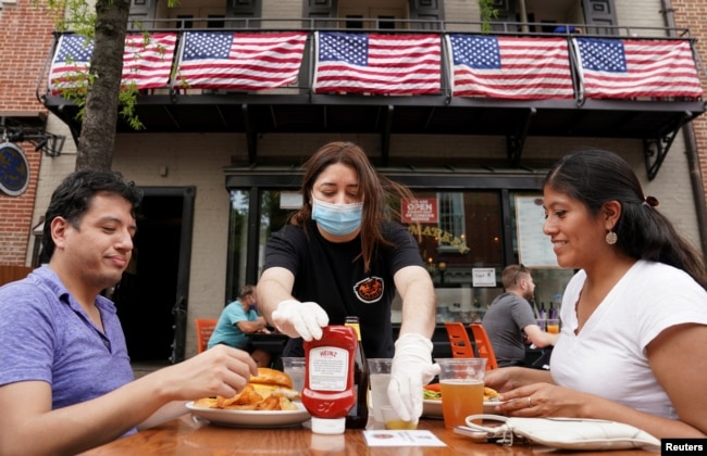 A waitress serves diners at a restaurant in Alexandria, Virginia, U.S., May 29, 2020. (REUTERS/Kevin Lamarque/File Photo)