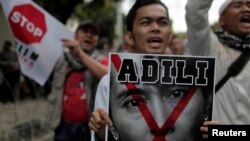 Seorang demonstran memegang poster bergambarkan Aung San Suu Kyi di depan Kedutaan Besar Myanmar di Jakarta, 25 November 2016.