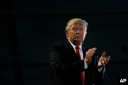 Republican presidential candidate Donald Trump applauds during a rally, Thursday, June 2, 2016.