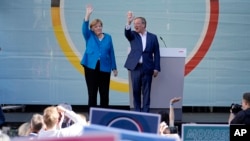 ထောက်ခံသူတွေကို နှုတ်ဆက်နေတဲ့ ဂျာမနီဝန်ကြီးချုပ် Angela Merkel နဲ့ CDU ပါတီဝင် ပြည်နယ်အုပ်ချုပ်ရေးမှူး Armin Laschet. (စက်တင်ဘာ ၂၅၊ ၂၀၂၁)