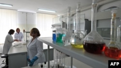 FILE - Scientists work in a laboratory in Kurchatov, Kazakhstan, Aug. 22, 2011.