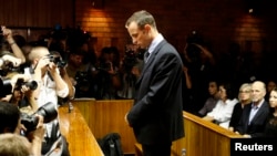 Bintang olimpiade Afsel, Oscar Pistorius berdiri dengan kepala menunduk sebelum dimulainya sidang di Pretoria, Jumat (22/2). 