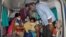 A patient is assisted to get down from an ambulance at the district government hospital in Eluru, Andhra Pradesh state, India, Dec.8, 2020, where health officials and experts are baffled by a mysterious illness that has left over 500 people hospitalized.