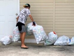 Genshu Price mengumpulkan kaleng dan botol daur ulang untuk penggalangan dananya, Bottles4College, di Hau'ula, Hawaii. (Foto: AP)