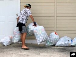 Genshu Price mengumpulkan kaleng dan botol daur ulang untuk penggalangan dananya, Bottles4College, di Hau'ula, Hawaii. (Foto: AP)