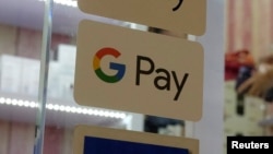 FILE - The Google Pay label is seen affixed to a window in a Hong Kong mall, July 31, 2018.