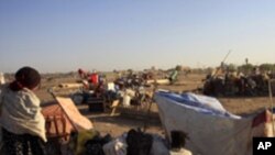 A family from southern Sudan, who has been staying in the north for 21 years, waits in Khartoum to be transported in a convoy back to the Abyei oil region. Southern.