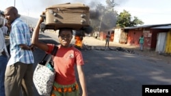 Une femme fuyant les affrontements entre des manifestants et des éléments de la sécurité à Bujumbura le 28 april 2015.