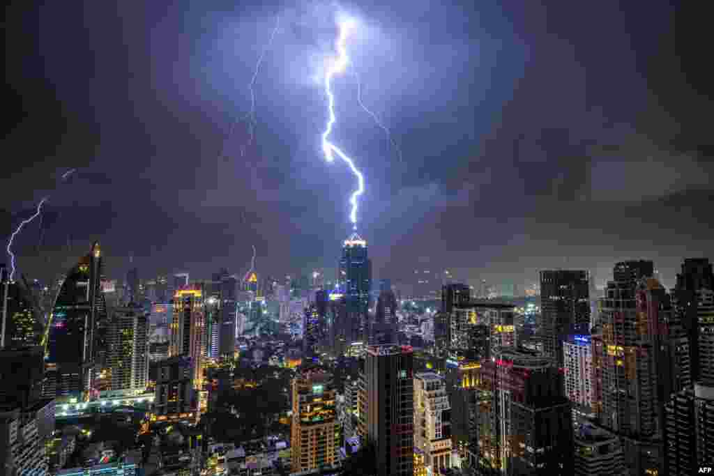 Lightening strikes on a building during a thunderstorm in Bangkok, Thailand.