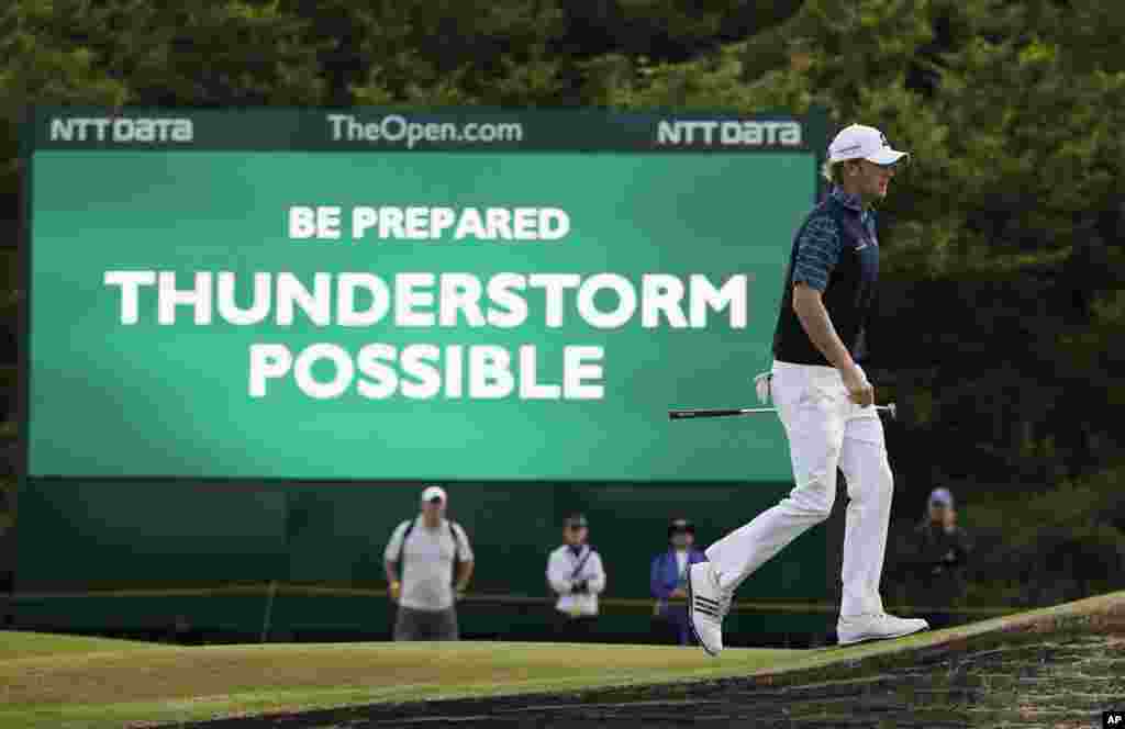 Brandt Snedeker of the U.S. walks past a digital sign showing a weather warning on the second day of the British Open Golf championship at the Royal Liverpool golf club, Hoylake, England.