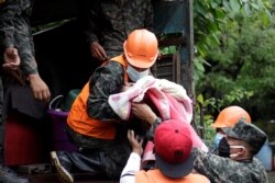 Honduran soldiers hold a baby as they evacuate residents in anticipation of heavy rains as Hurricane Iota approaches, in Marcovia, Honduras, Nov. 17, 2020.