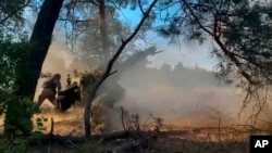 En esta fotografía tomada de un vídeo publicado por el Ministerio de Defensa ruso el viernes 12 de julio de 2024, soldados rusos disparan con su obús desde su posición contra las tropas ucranianas en un lugar no revelado de Ucrania.