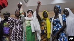 Pakistani activist Malala Yousafzai, center, was named a winner of the Nobel Peace Prize. She's shown with escaped kidnapped school girls from Chibok in Abuja, Nigeria, July 14, 2014. 