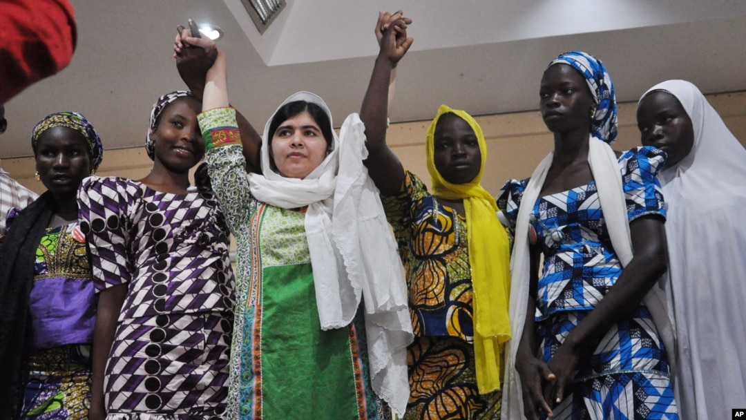 Pakistani activist Malala Yousafzai, center, was named a winner of the Nobel Peace Prize. She's shown with escaped kidnapped school girls from Chibok in Abuja, Nigeria, July 14, 2014. 