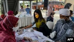 Petugas kesehatan memeriksa tekanan darah warga sebelum divaksinasi dengan vaksin COVID-19 Sinovac di Banda Aceh, 10 Juni 2021.