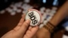 FILE - An Egyptian buys a pin with the Boycott, Divestment and Sanctions (BDS) logo during the launch of the Egyptian campaign that urges boycott, divestment and sanctions against Israel. The BDS campaign is behind the proposed boycott of Israeli universi