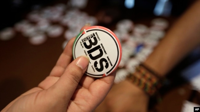 FILE - An Egyptian buys a pin with the Boycott, Divestment and Sanctions (BDS) logo during the launch of the Egyptian campaign that urges boycott, divestment and sanctions against Israel.
