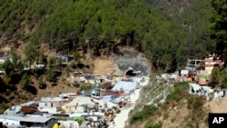 FILE- Heavy machinery is parked at the entrance to the site of an under-construction road tunnel that had collapsed trapping 40 workers in Silkyara in the northern Indian state of Uttarakhand, Nov. 22, 2023.