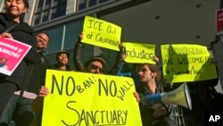 Демонстранты в Калифорнии держат плакаты в поддержку "городов-убежищ"