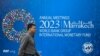 FILE - A pedestrian walks past a billboard announcing the World Bank Group and International Monetary Fund annual meetings, on the side of the International Monetary Fund headquarters in Washington, DC, on October 5, 2023.