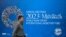 FILE - A pedestrian walks past a billboard announcing the World Bank Group and International Monetary Fund annual meetings, on the side of the International Monetary Fund headquarters in Washington, DC, on October 5, 2023.