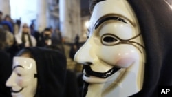 ພວກປະທ້ວງໃສ່ໜ້າກາກ ທີ່ເອີ້ນຕົນເອງວ່າ ກຸ່ມ Anonymous ເຂົ້າຮ່ວມການປະທ້ວງທີ່ນະຄອນ Brussels ປະເທດເບລຢ້ຽມ (28 ມັງກອນ 2012)