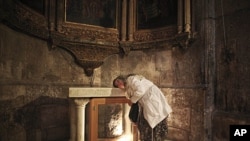 A Christian pilgrim rests her head on an altar as she prays inside the church of the Holy Sepulcher, the site where many Christians believe Jesus Christ was crucified and buried, Jerusalem, April 24, 2011