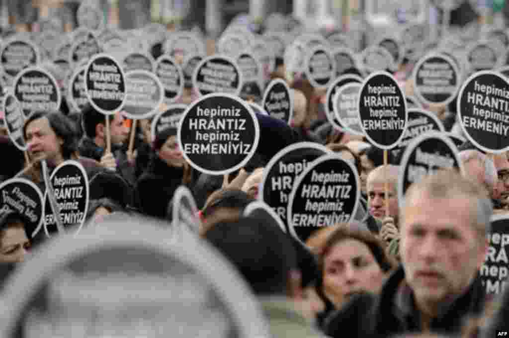 Protesters hold signs reading "We are all Hrant, we are all Armenian" as tens of thousands of protesters march to mark the fifth anniversary of Turkish-Armenian journalist Hrant Dink's murder in Istanbul, Turkey, Thursday, Jan. 19, 2012, as outrage contin