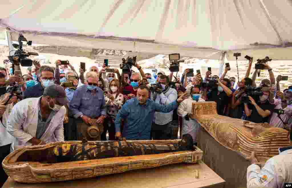 Egyptian Minister of Tourism and Antiquities Khaled Al-Anani (L), and Mustafa Waziri (R), Secretary General of the Supreme Council of Antiquities unveil the mummy inside a sarcophagus excavated at the Saqqara necropolis, south of the capital Cairo.