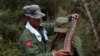 FILE - A rebel soldier of Myanmar National Democratic Alliance Army (MNDAA) places a machine gun bullet belt around the neck of another soldier at a military base in Kokang region, March 10, 2015.