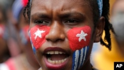 Seorang mahasiswa Papua dengan wajah dicat bendera "Bintang Kejora" meneriakkan slogan-slogan dalam unjuk rasa di depan Istana Kepresidenan di Jakarta, 28 Agustus 2019. 