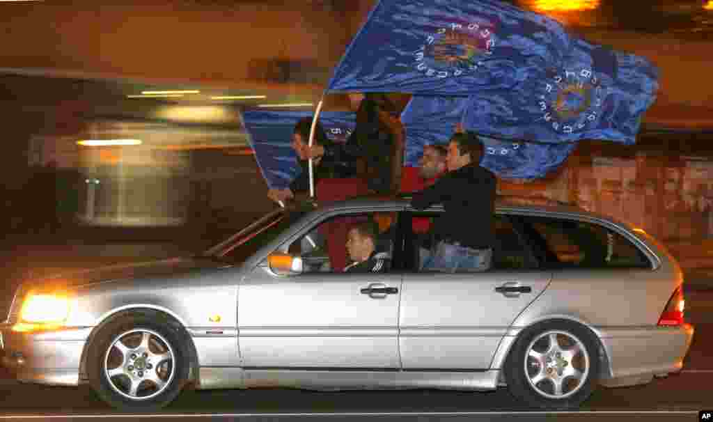 People drive with the Georgian Dream coalition flags as they celebrate following elections in Tbilisi, Oct. 27, 2013. 