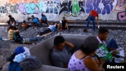 Migrantes que tratan de llegar hasta EEUU descansan en la ciudad fronteriza mexicana de Ciudad Juárez el 26 de julio de 2023.